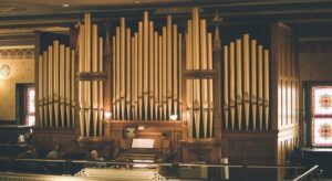 Historische Kirchenorgel mit zahlreichen goldfarbenen Pfeifen und Spieltisch