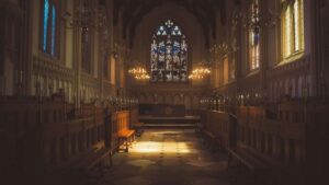 Innenraum einer historischen Kirche mit Altar, Kerzen und Buntglasfenster