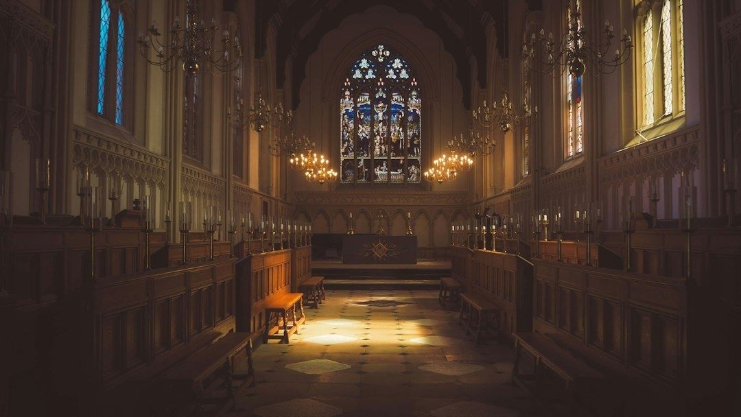 Innenraum einer historischen Kirche mit Altar, Kerzen und Buntglasfenster