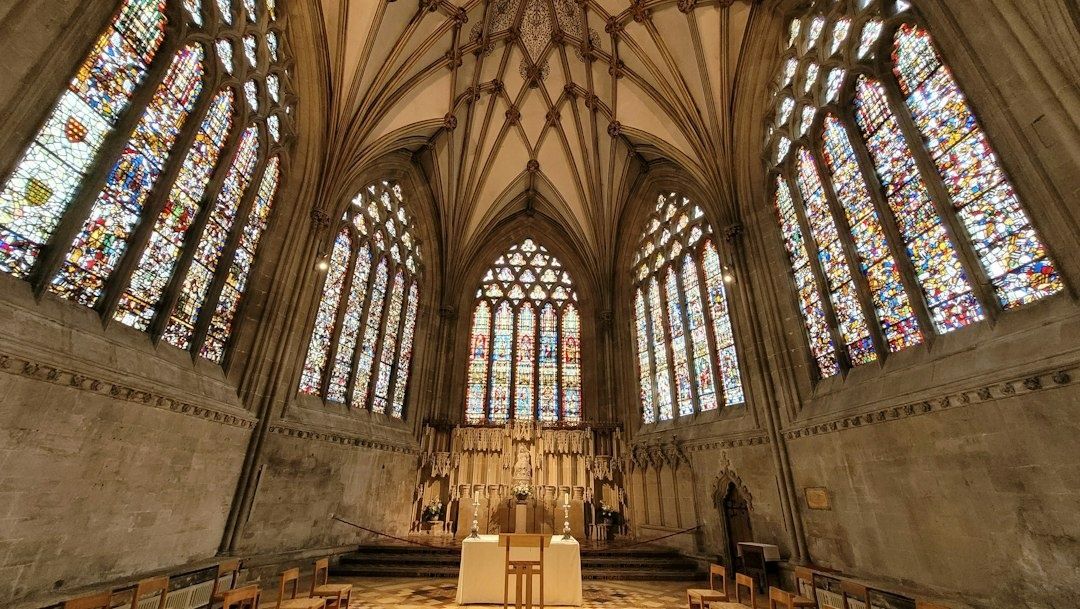 Historischer Kirchenraum mit farbigen Fenstern und schlichtem Altar